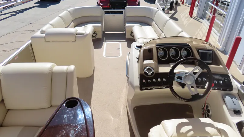 Slide: The Image of 2013 Bennington 2875 QCW I/O boat interior with beige seating and modern dashboard. - 24