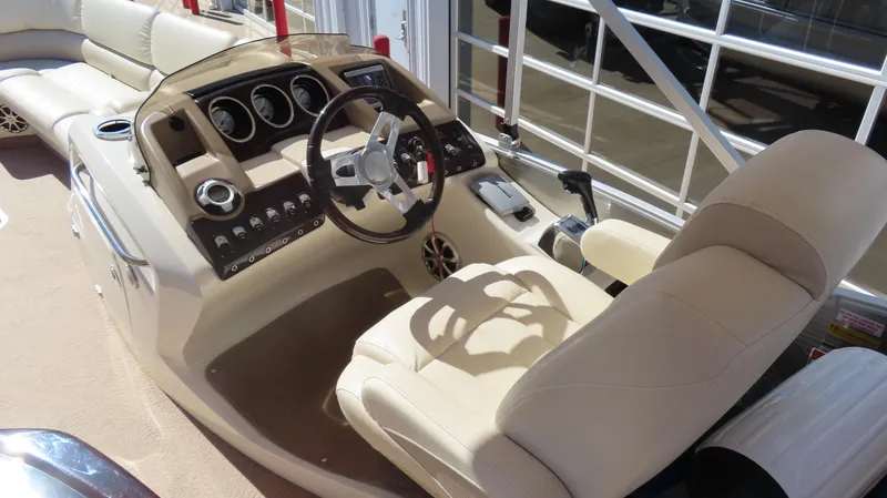 Slide: The Image of 2013 Bennington 2875 QCW I/O boat interior with beige captain's chair and control panel. - 25