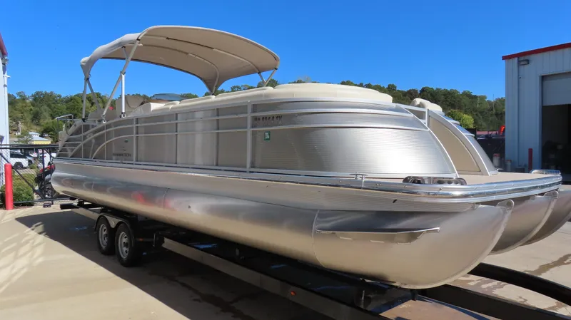 Slide: The Image of 2013 Bennington 2875 QCW I/O pontoon boat on trailer, parked outdoors. - 3