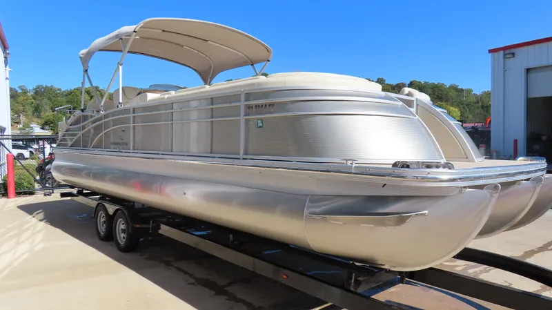 Slide: The Image of 2013 Bennington 2875 QCW I/O pontoon boat on trailer, parked outdoors. - 4