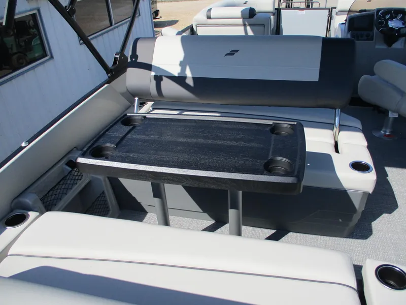 Slide: The Image of 2025 Starcraft EXS-3DL boat interior with seating and table, featuring cup holders. - 17