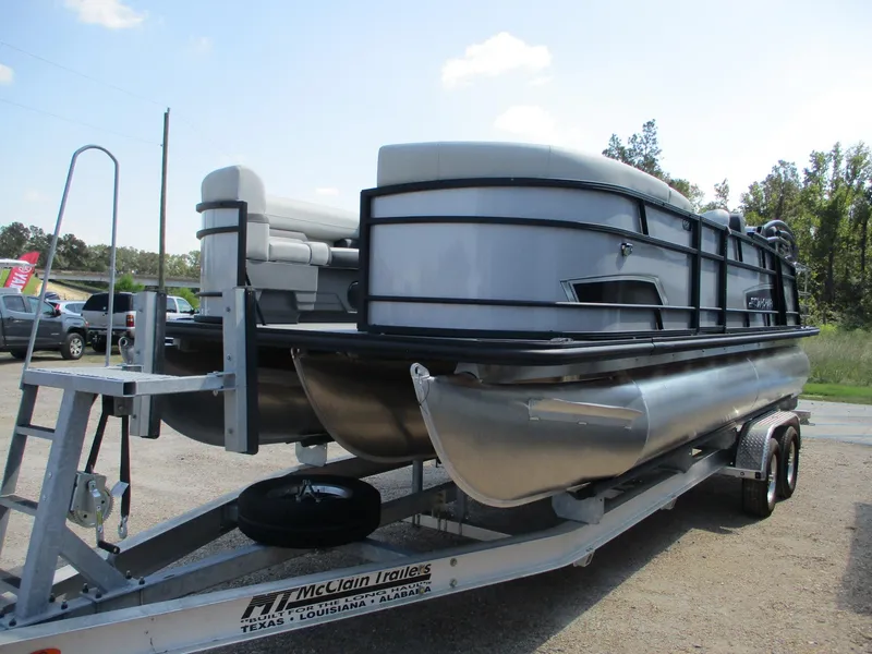 Slide: The Image of 2025 Starcraft EXS-3DL pontoon boat on trailer, parked outdoors. - 7