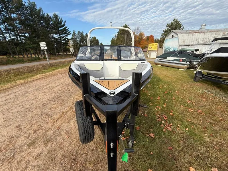 Slide: The Image of 2025 Nautique Ski 200 Open Bow boat on trailer, outdoor display. - 13