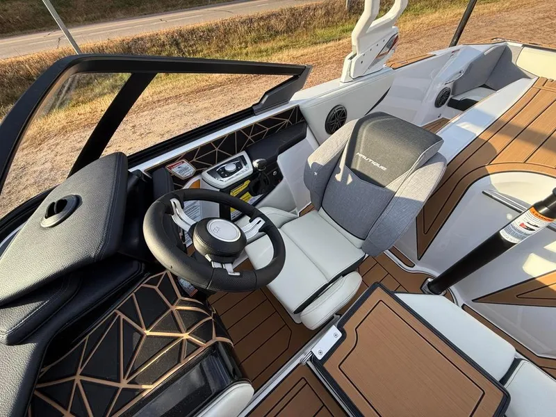 Slide: The Image of 2025 Nautique Ski 200 Open Bow interior with modern steering and seating design. - 25