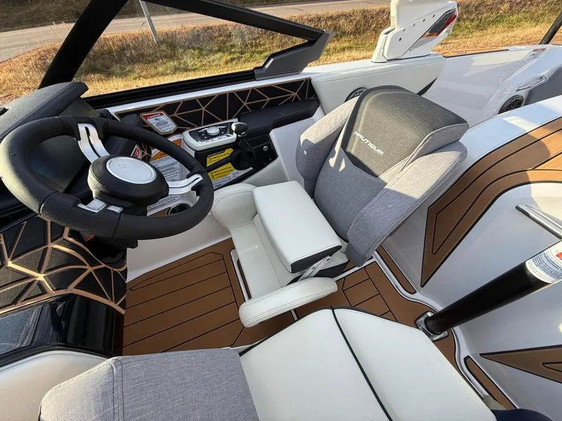 Slide: The Image of Interior of 2025 Nautique Ski 200 Open Bow boat with modern steering and seating. - 26