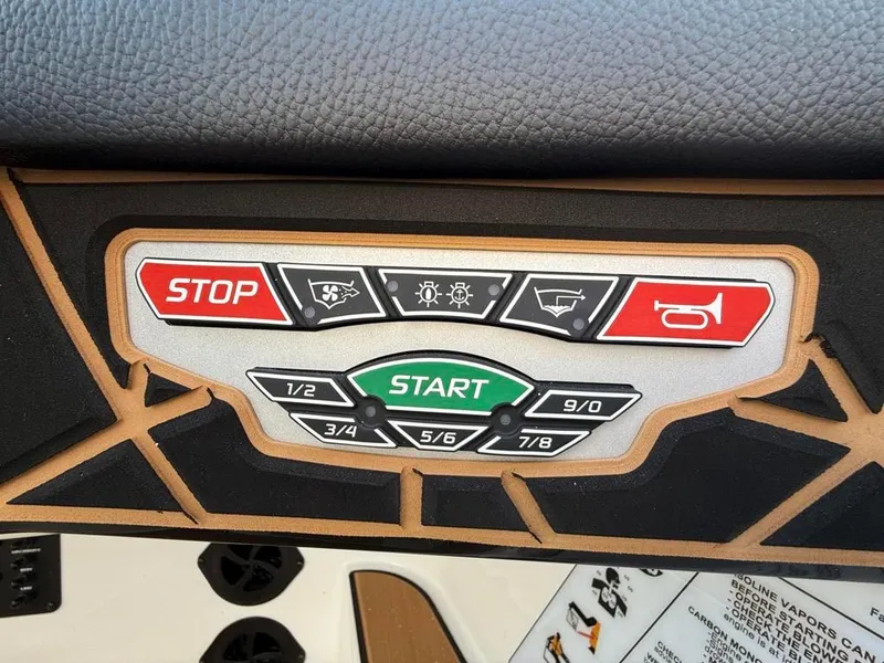 Slide: The Image of Control panel of 2025 Nautique Ski 200 Open Bow boat with start and stop buttons. - 28