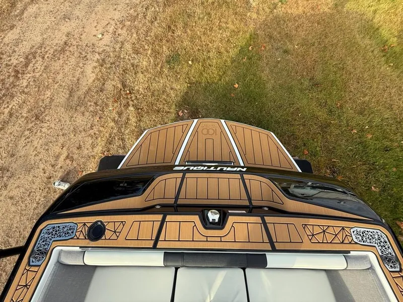 Slide: The Image of 2025 Nautique Ski 200 Open Bow boat, top view, on grass and dirt. - 42