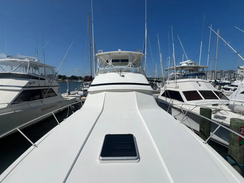 Slide: The Image of 1989 Bertram 50 Convertible yacht docked at marina, surrounded by other boats. - 12