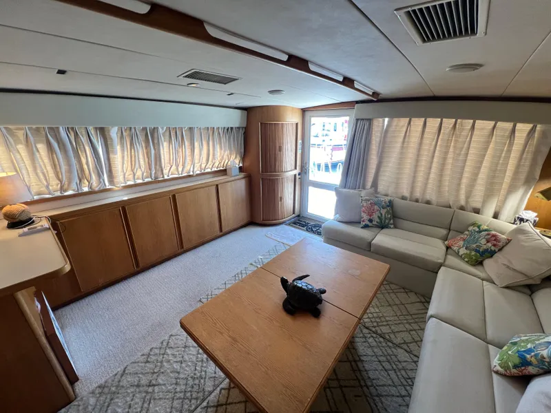 Slide: The Image of Interior of 1989 Bertram 50 Convertible yacht with cozy seating and wooden accents. - 16