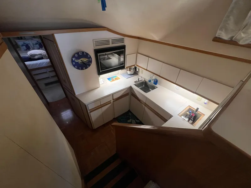 Slide: The Image of 1989 Bertram 50 Convertible yacht interior kitchen with white cabinets and sink. - 20