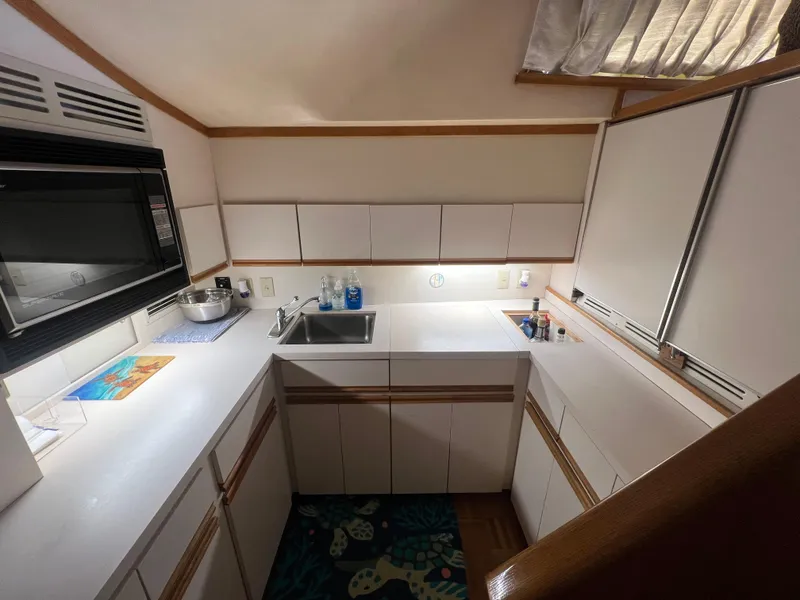 Slide: The Image of 1989 Bertram 50 Convertible yacht kitchen with white cabinets and modern appliances. - 21