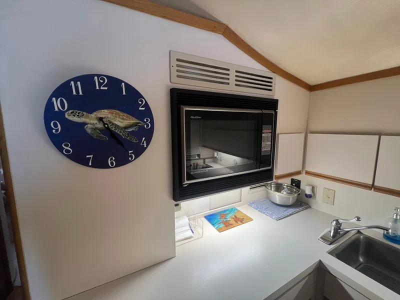 Slide: The Image of 1989 Bertram 50 Convertible kitchen with turtle clock and built-in microwave. - 22