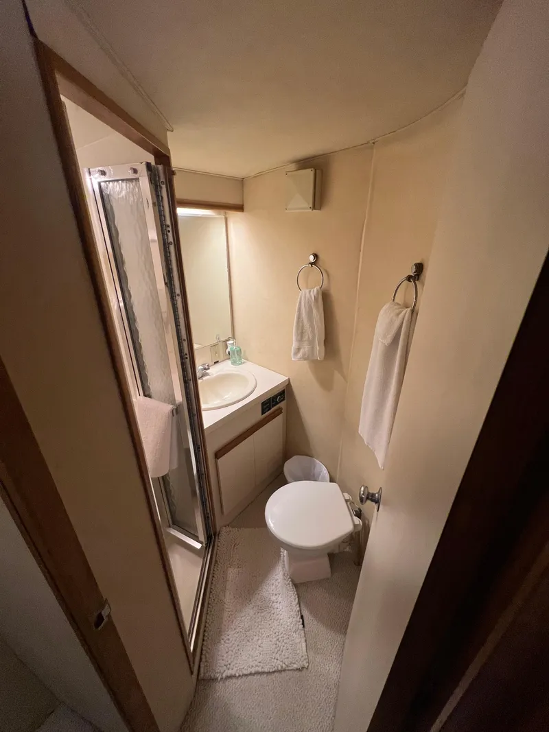 Slide: The Image of Compact bathroom in 1989 Bertram 50 Convertible yacht with shower, sink, and toilet. - 25