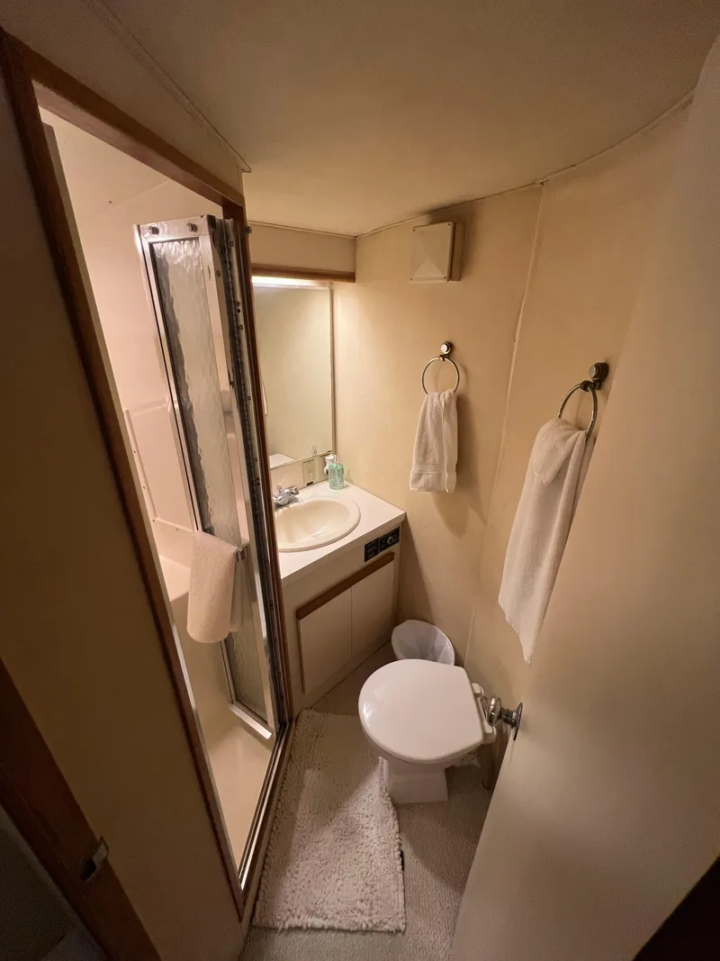 Slide: The Image of Compact bathroom in 1989 Bertram 50 Convertible yacht with shower, sink, and toilet. - 28