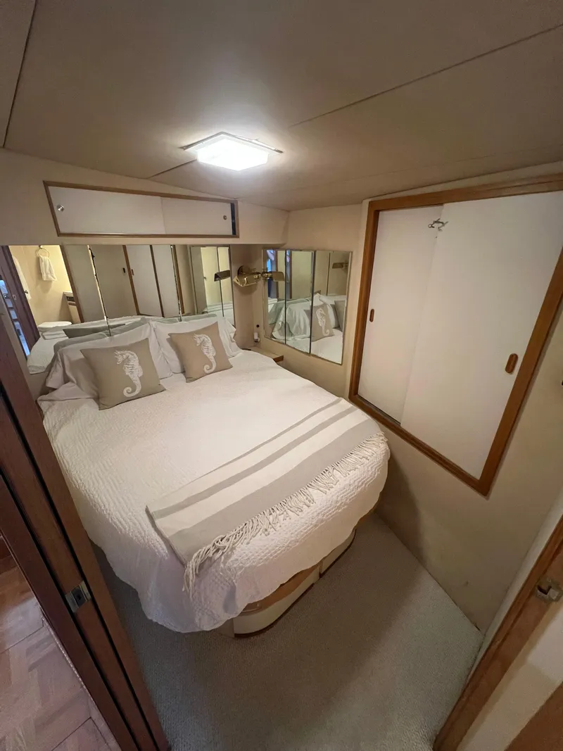 Slide: The Image of Cozy bedroom in 1989 Bertram 50 Convertible yacht with elegant decor and mirrored accents. - 30