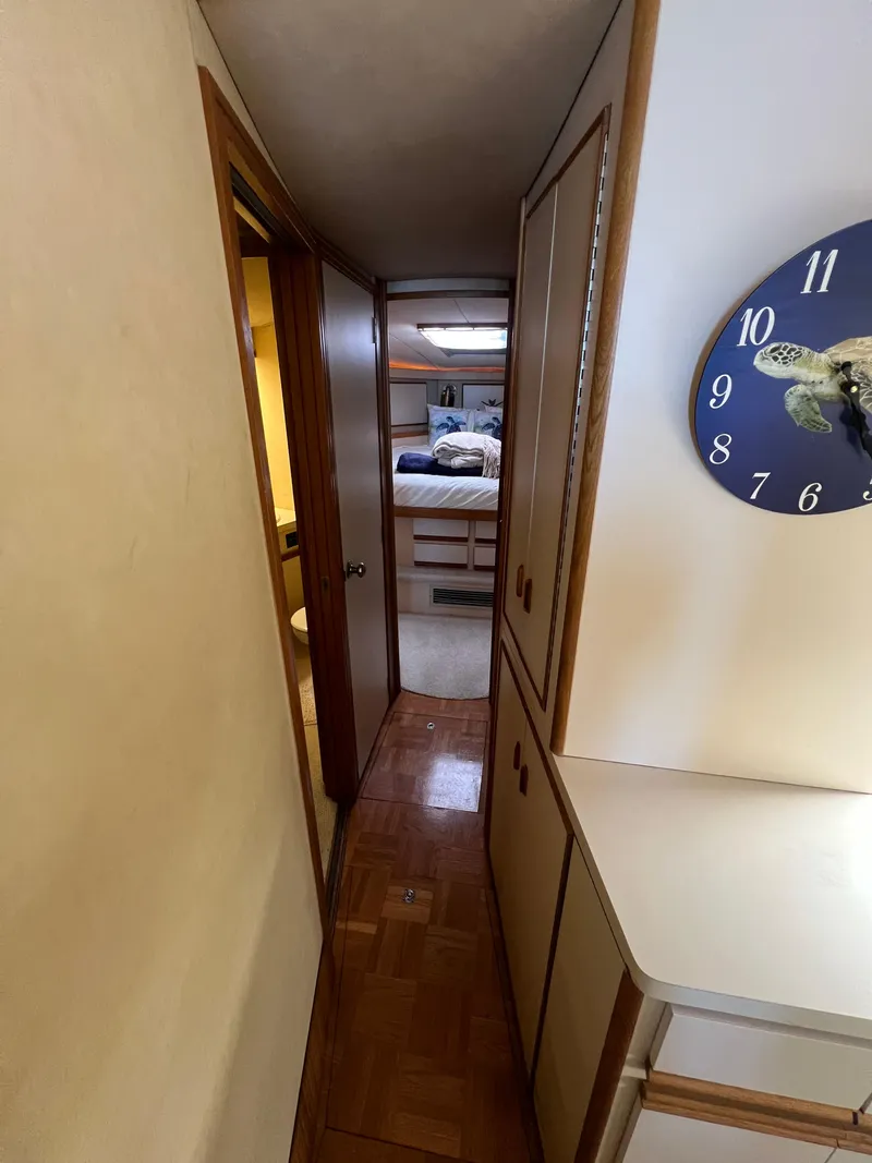 Slide: The Image of Narrow hallway inside 1989 Bertram 50 Convertible yacht, featuring a turtle-themed wall clock. - 31