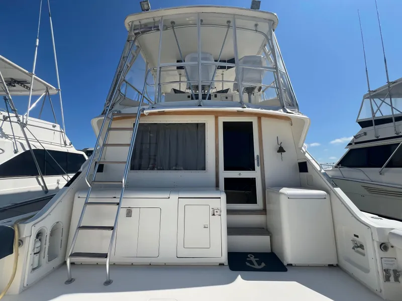 Slide: The Image of 1989 Bertram 50 Convertible yacht, rear view with ladder and deck, under clear blue sky. - 4