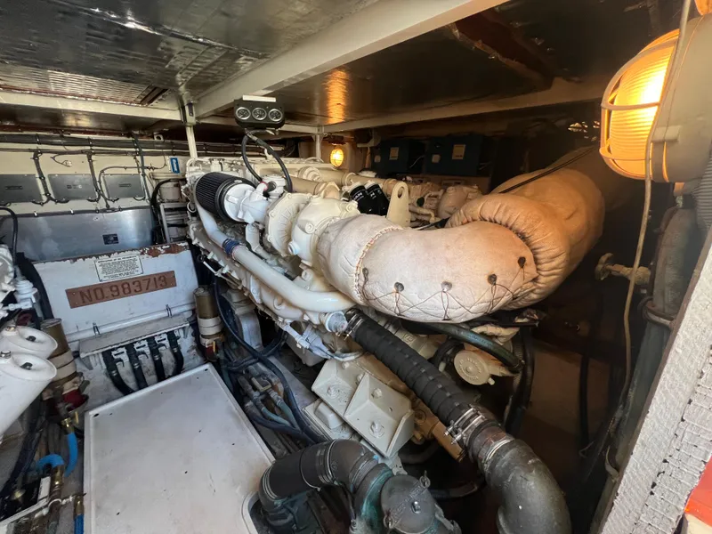 Slide: The Image of Engine room of 1989 Bertram 50 Convertible yacht, showcasing mechanical components and lighting. - 45