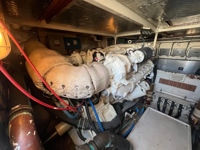 Slide: The Image of Engine room of 1989 Bertram 50 Convertible yacht, showcasing detailed machinery and components. - 46