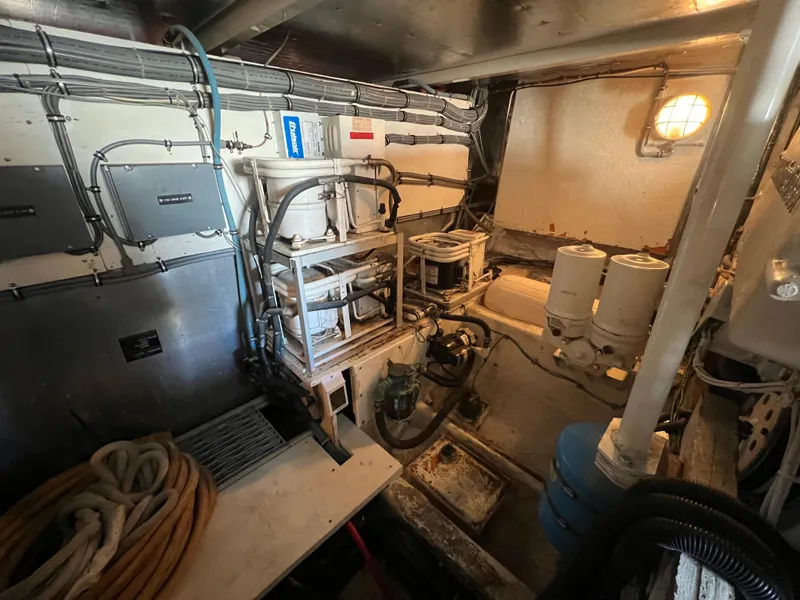 Slide: The Image of Engine room of 1989 Bertram 50 Convertible boat with equipment and wiring. - 47