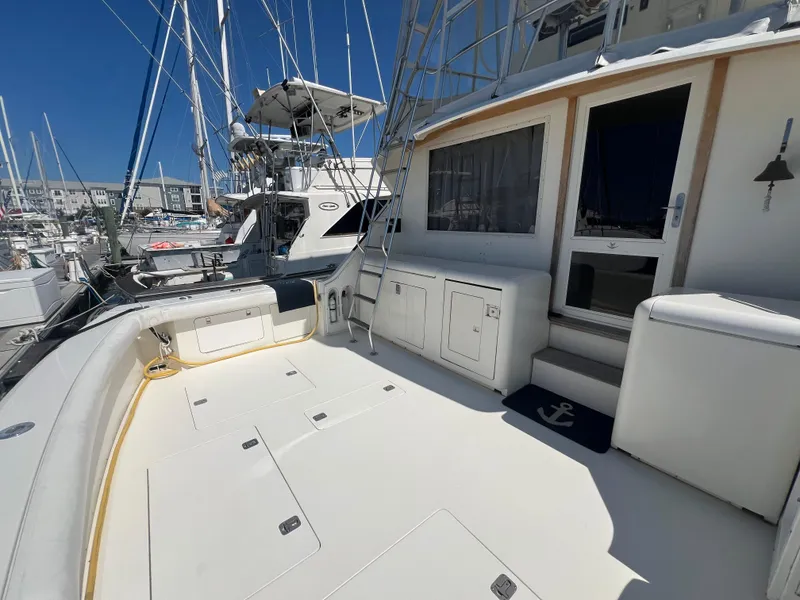 Slide: The Image of 1989 Bertram 50 Convertible yacht deck with storage and seating, docked at marina. - 5