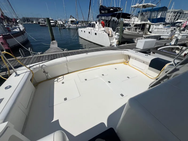 Slide: The Image of 1989 Bertram 50 Convertible yacht docked at marina, spacious deck area, surrounded by other boats. - 8