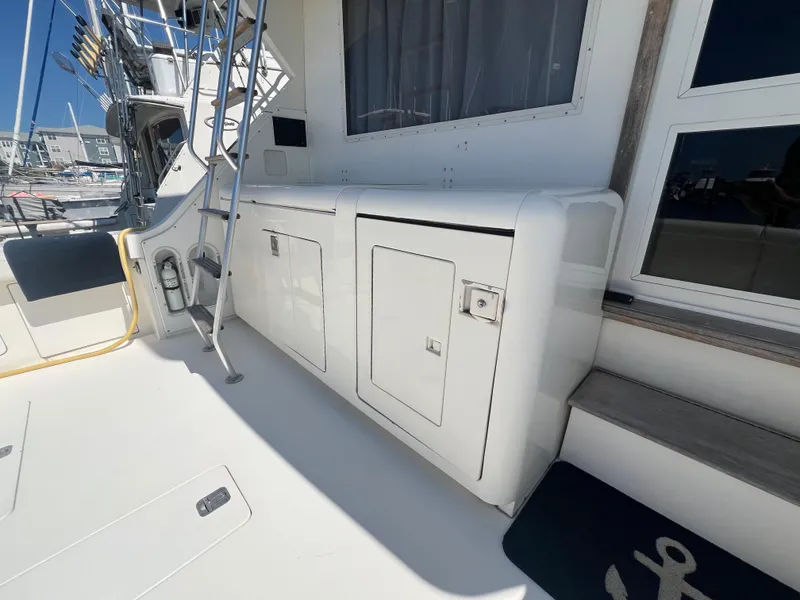Slide: The Image of 1989 Bertram 50 Convertible yacht deck with storage compartments and ladder. - 9