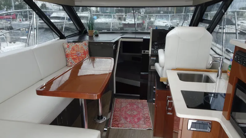 Slide: The Image of Interior of 2018 Carver C34 Coupe yacht with modern seating and kitchen area. - 18