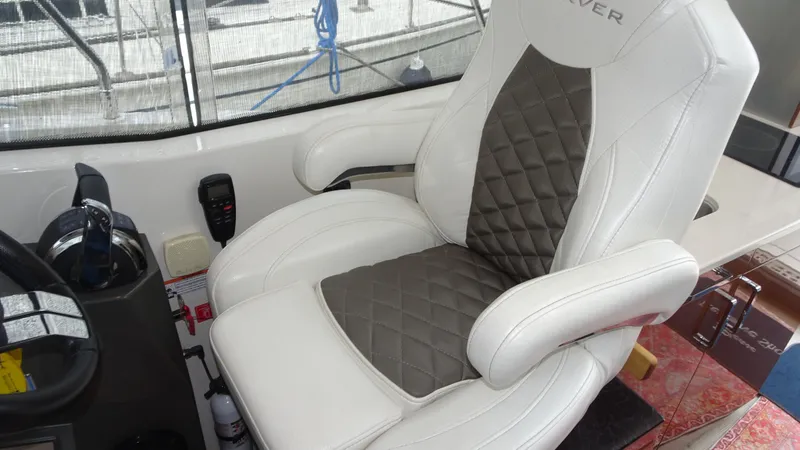 Slide: The Image of Captain's chair in 2018 Carver C34 Coupe, featuring quilted upholstery and armrests. - 23