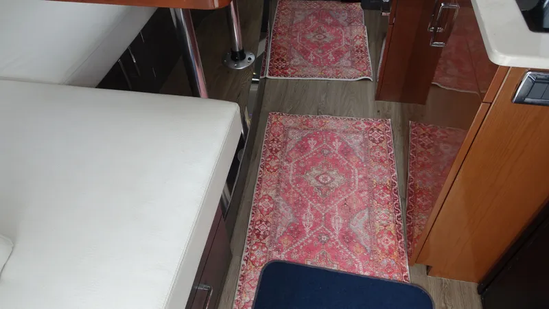 Slide: The Image of Interior of 2018 Carver C34 Coupe with patterned rugs and wooden cabinetry. - 26