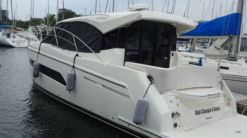 The Image of 2018 Carver C34 Coupe yacht docked at marina with protective covers. - 0