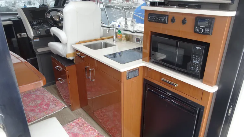 Slide: The Image of Interior of 2018 Carver C34 Coupe yacht with kitchenette and helm station. - 19