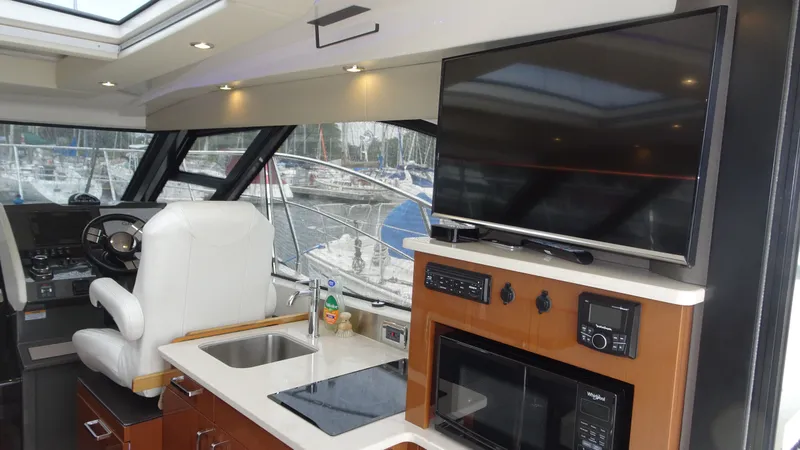 Slide: The Image of Interior of 2018 Carver C34 Coupe yacht with helm, TV, and kitchenette. - 20