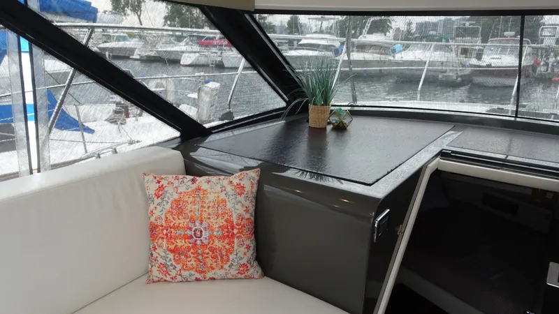 Slide: The Image of Interior of 2018 Carver C34 Coupe with decorative pillow and marina view. - 21