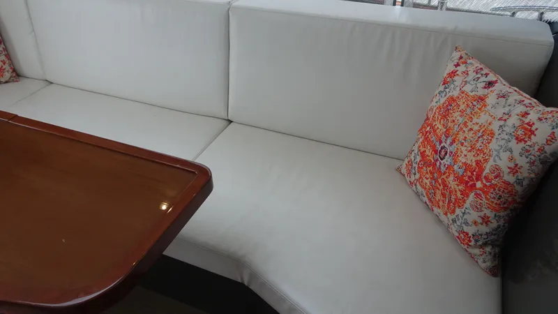 Slide: The Image of Interior of 2018 Carver C34 Coupe with white seating and decorative pillow. - 24