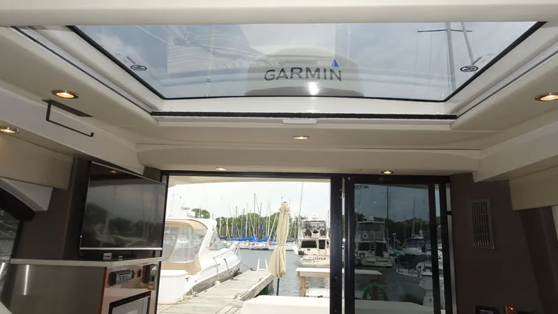 Slide: The Image of Interior view of 2018 Carver C34 Coupe yacht with skylight and marina backdrop. - 30