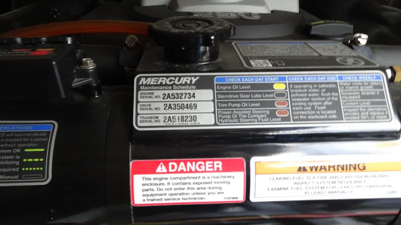 Slide: The Image of Engine maintenance labels on a 2018 Carver C34 Coupe, featuring Mercury maintenance schedule. - 48