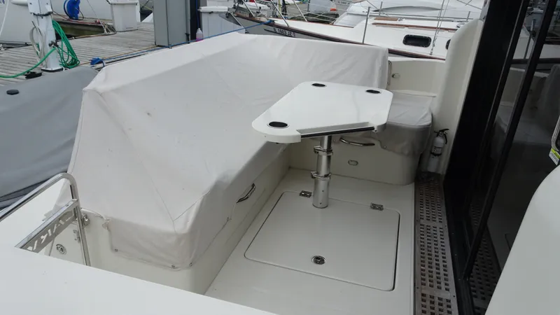 Slide: The Image of 2018 Carver C34 Coupe yacht cockpit with covered seating and adjustable table. - 7