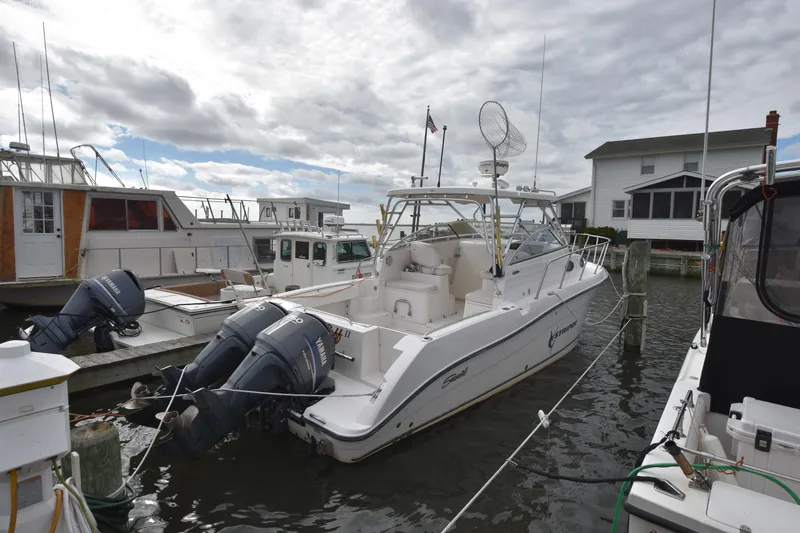 Slide: The Image of 2007 Seaswirl Striper 2901 Walkaround O/B docked at marina under cloudy sky. - 0