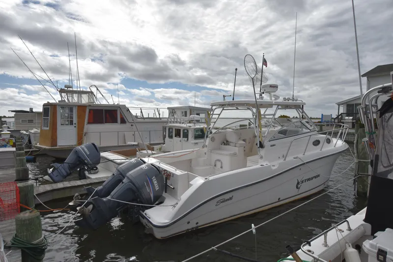 Slide: The Image of 2007 Seaswirl Striper 2901 Walkaround O/B docked at marina under cloudy sky. - 1