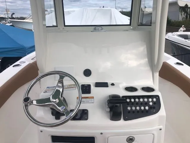Slide: The Image of 2023 NauticStar 242L Offshore boat dashboard with steering wheel and controls. - 4