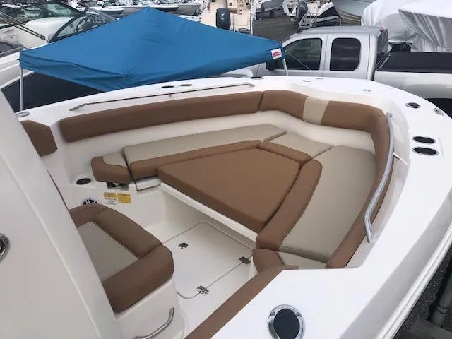 Slide: The Image of 2023 NauticStar 242L Offshore boat with spacious seating and blue canopy. - 5