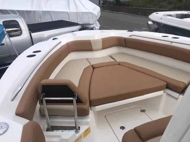 Slide: The Image of 2023 NauticStar 242L Offshore boat with tan and white seating in the bow area. - 7