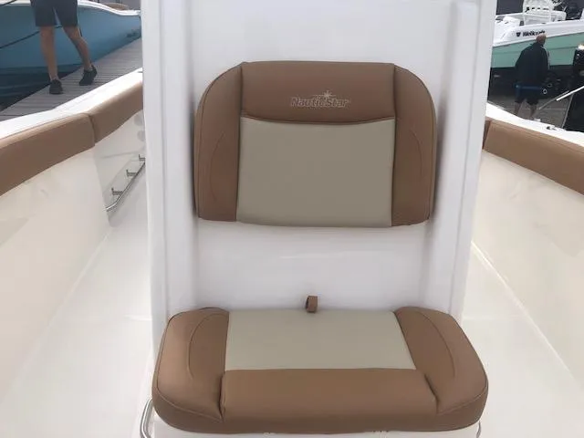 Slide: The Image of 2023 NauticStar 242L Offshore boat seat with tan and beige cushions. - 8