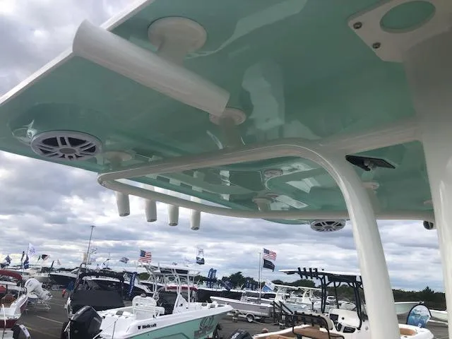 Slide: The Image of 2023 NauticStar 242L Offshore boat with teal canopy at a marina. - 9