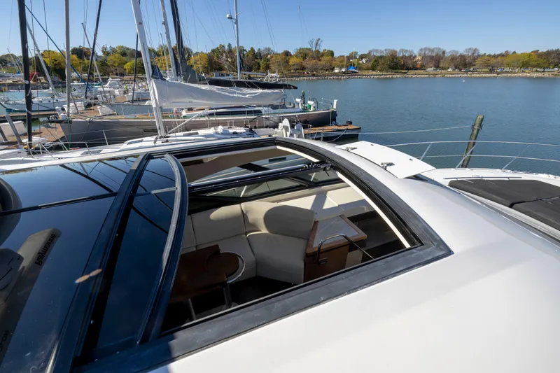Slide: The Image of 2016 Sea Ray 510 Sundancer yacht with open sunroof, docked in a marina. - 32