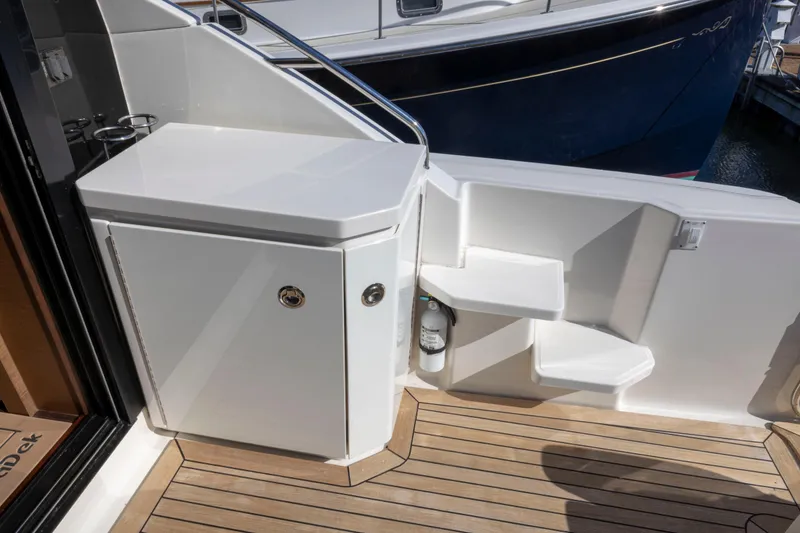 Slide: The Image of 2016 Sea Ray 510 Sundancer yacht deck with white cabinetry and steps. - 41