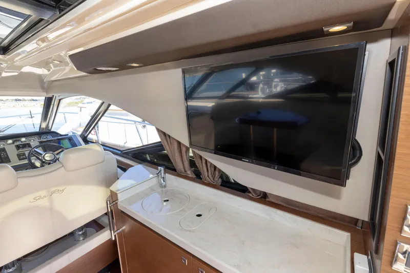 Slide: The Image of Interior of 2016 Sea Ray 510 Sundancer yacht with TV and helm station. - 48
