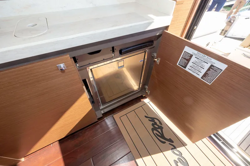 Slide: The Image of Interior view of 2016 Sea Ray 510 Sundancer yacht, featuring an open cabinet with a mini fridge. - 49