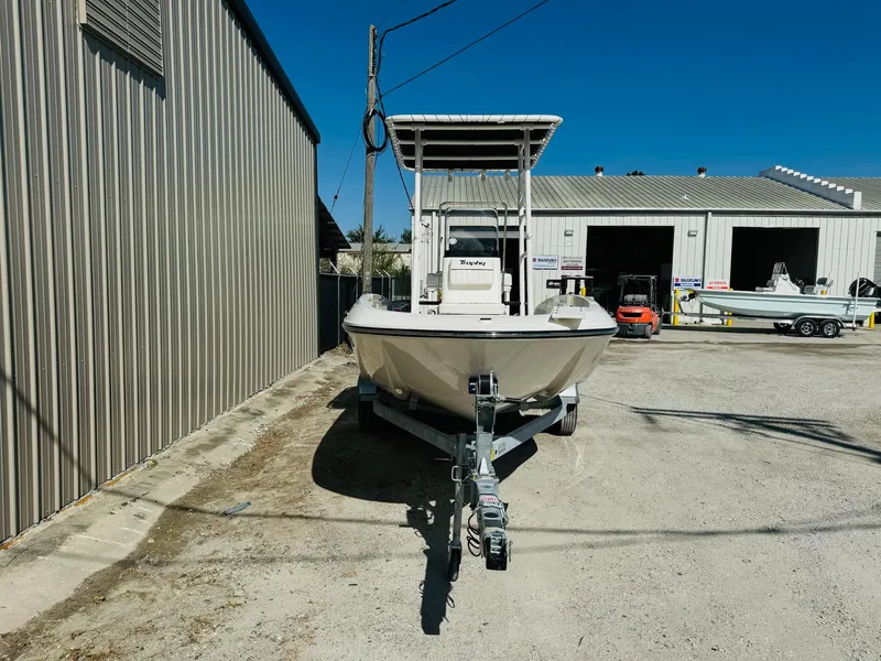 Slide: The Image of 2025 Bayliner Trophy T18 boat on trailer outside a warehouse. - 2